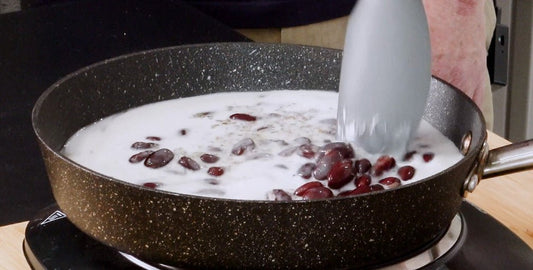 Rice and peas cooking in coconut milk in a saucepan